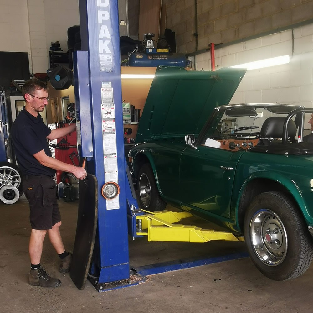 Picture - Classic TR6 on the lift with Gavin operating